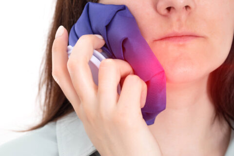 An Atlanta woman holding a cold pack against her cheek to relieve an aching tooth