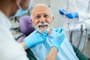 The old man with happy face when treatment on process in Atlanta oral surgery, GA.