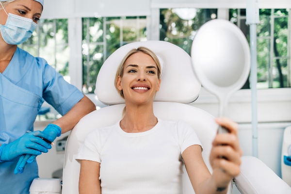 Smiling facial implant patient admiring her face