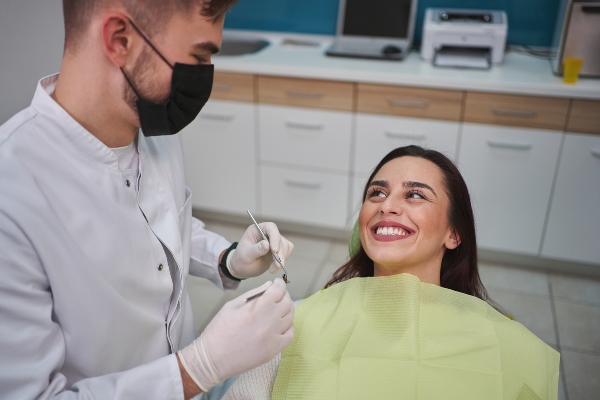 Smiling patient being examined for periodontal disease