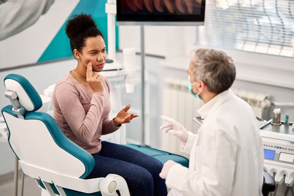 Woman explaining wisdom tooth pain to oral surgeon